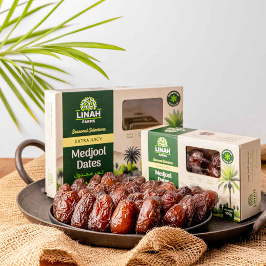 two boxes of Linah Farms' extra juicy medjool dates with a plate full of extra juicy medjool dates in front of the boxes