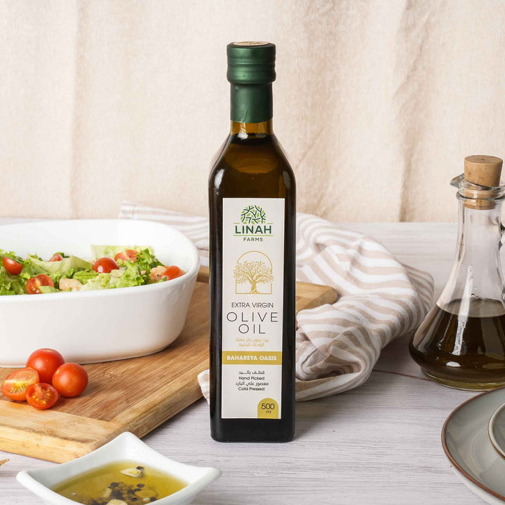 Close-up of Linah Farms' premium extra-virgin olive oil bottle with a salad bowl on the side